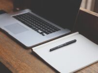 ノートPCとノート、ペンの画像